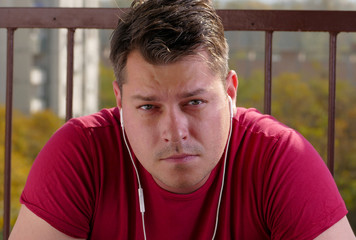 Man listening to music on a balcony