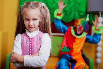 Obraz na płótnie Canvas Upset little girl standing in the playroom. 