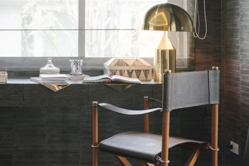 working table with wooden chair, books and lamp in modern working room