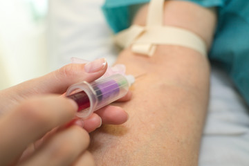 nurse pricking needle syringe to collect blood