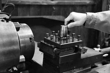 Craftsman using the Obsolete lathe. Black-and-white photo.