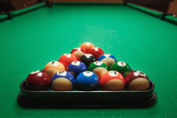 Two cues and pyramid on a billiard table.