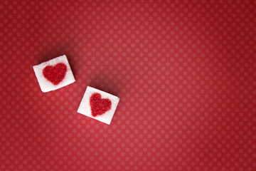 Sugar cubes with a red heart on them. Top view. Sweet addiction valentine day concept