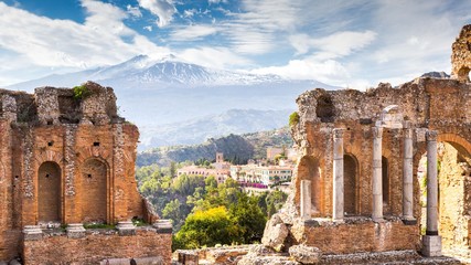 Ruins and columns of antique greek theater in Taormina and Etna Mount in the background. Sicily,...