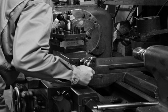 Craftsman using the Obsolete lathe. Black-and-white photo.