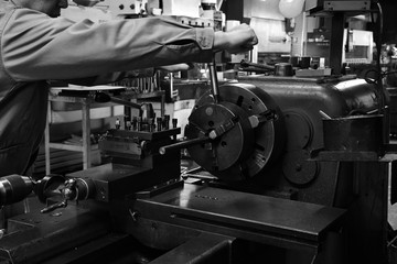 Craftsman using the Obsolete lathe. Black-and-white photo.