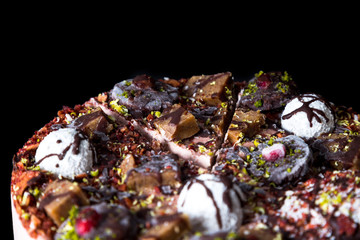 Raw vegan cake on a black plate on a dark background
