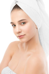 Beautiful young brunette woman with clean face and towel on her head. Beauty spa model girl perfect fresh clean skin. Youth and skin care concept. Isolated.