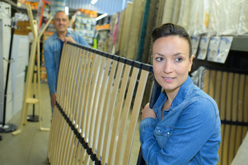 two workers carrying a bed frame in warehouse