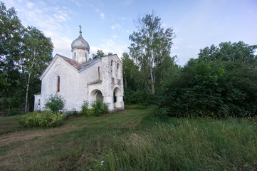 Fototapeta na wymiar Orthodox Church and nature. Green garden and architecture. Under the blue sky a house which is surrounded by a beautiful natural environment. Trees, bushes and building - Piirissaar, Estonia, Europe.
