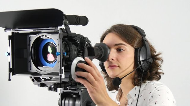 beautiful young woman with DSLR video camera and headphones