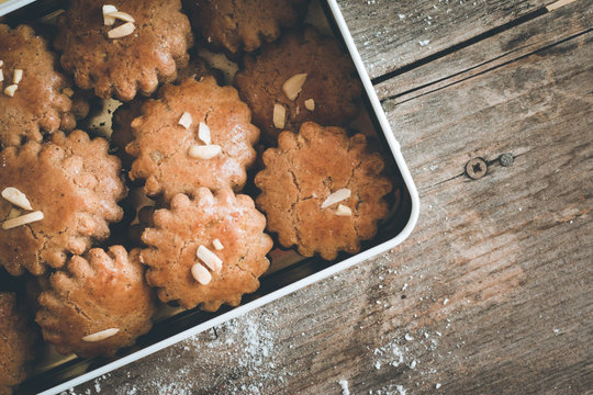 Blechdose mit Lebkuchenpl&auml;tzchen, auf rustikalem Holz
