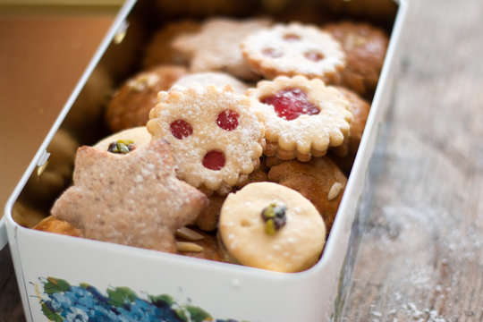 Blechdose mit Weihnachtspl&auml;tzchen und Lebkuchen, auf rustikalem Holz