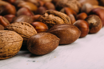 Nuts set almonds, hazelnuts, peanuts, Brazil nuts, walnuts on white texture background