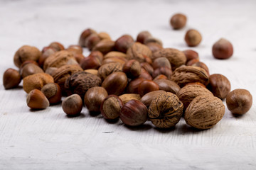 Nuts set almonds, hazelnuts, peanuts, Brazil nuts, walnuts on white texture background