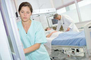 sad female nurse at hospital corridor