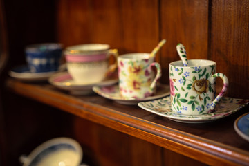 Line of four cups on the wooden shelf in a vintage shop in Bruges, Belgium