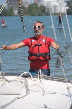 portrait of mature sportsman near catamaran