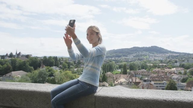 Selfie woman - Tourist taking self portrait photography picture with smartphone and regular photo at view point in Bern  Switzerland. Smart phone and travel concept. REAL TIME RED EPIC.