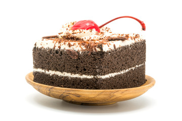 Chocolate cake garnished with cherry and white cream