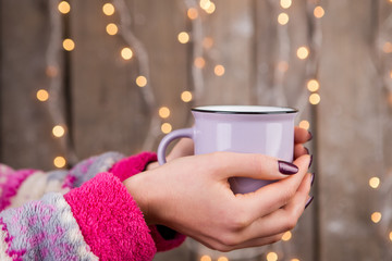 Woman in cozy sweater holding a cup