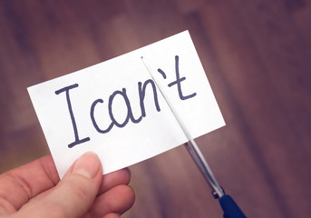 Success self motivation concept. Hand cutting phrase I can not cut by scissors and became I can