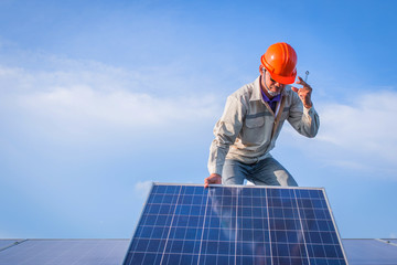 engineer or electrician working on replacement solar panel in solar power plant; working on Wrench tightening solar mounting structure of solar panel 