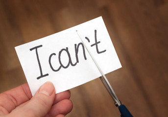 Success self motivation concept. Hand cutting phrase I can not cut by scissors and became I can