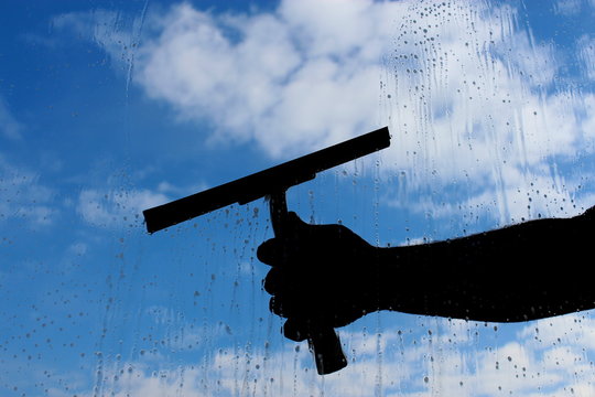 man cleaning the window with cloudy background