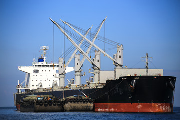 Cargo ship sailing in still water.