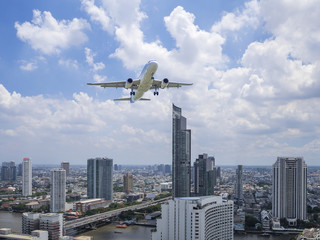 Fototapeta na wymiar Airplane flying over modern building 1