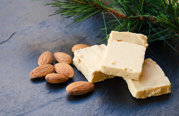 .Turron, typical Christmas sweet in Spain. Almond nougat on black stone background..