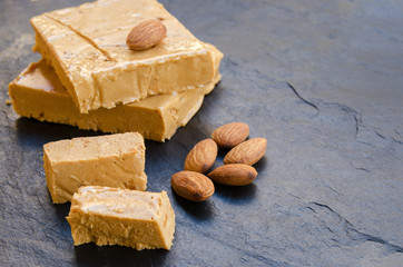 .Turron, typical Christmas sweet in Spain. Almond nougat on black stone background..