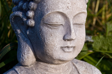 Obraz premium Buddha face on sunny meadow.