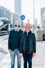 Two man wearing alien masks posing outdoor in the city back light - strange, carnival, halloween...