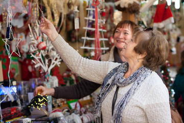 female pensioners buying X-mas decorations at fair