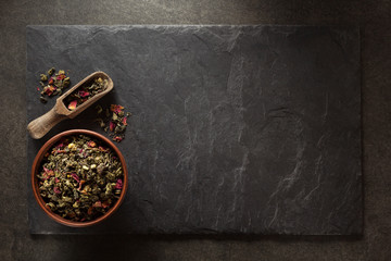 bowl of  of dry tea and scoop at slate