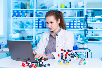 Woman scientist holding model of molecule or crystal lattice. scientist working at the laboratory....