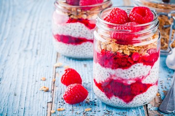 healthy breakfast: chia pudding with raspberry sauce, granola and fresh raspberries