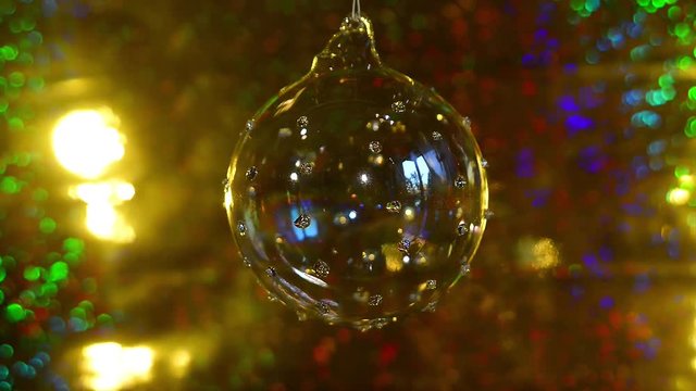 Palla di Natale di vetro che ruota sul filo  - sfondo colorato e luccicante - Buon Natale