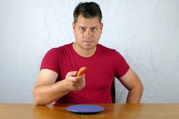 Young man dislike carrot on plate, healty food concept.