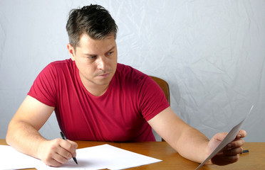 Young man writing on a paper