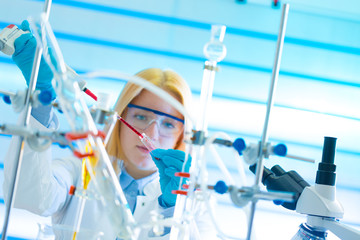 Assistant in laboratory with pipette research of cancer stem cells. .Female medical or scientific...