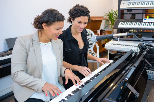 Women playing duet on keyboard