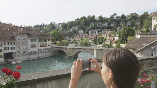 Woman taking photograph picture in Bern with smart phone walking in Bern  Switzerland. Travel concept with multicultural Asian Caucasian girl. RED EPIC 60 FPS SLOW MOTION.