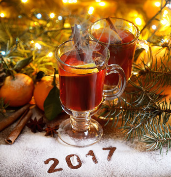 2017 New Year.Mulled wine with spices and tangerines on wooden background
