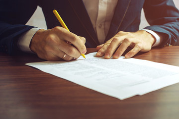 Man businessman signs documents with a pen