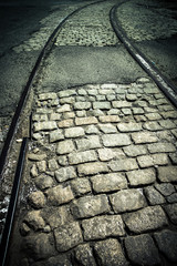 Dark cobblestone and old train track rails