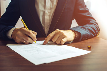 Man businessman signs documents with a pen