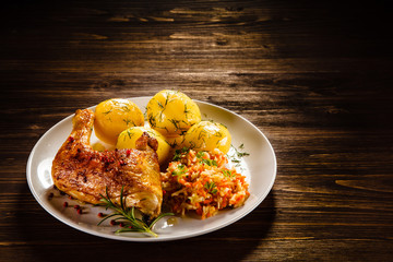 Grilled chicken leg with boiled potatoes and vegetable salad 